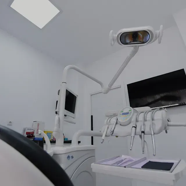 Un consultorio dental con un sillón dental y equipo dental.
