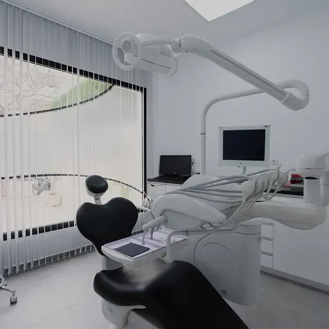 Un consultorio dental con un sillón dental y una computadora.