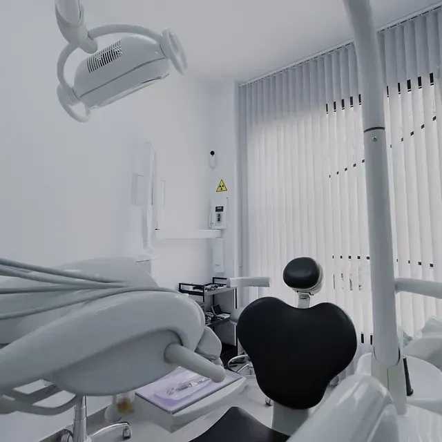 Un consultorio dental con un sillón dental y una lámpara dental.