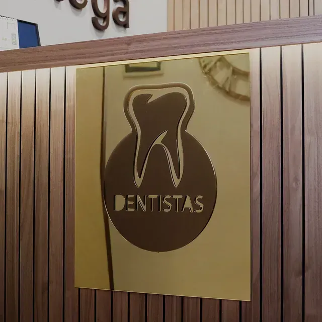 Un cartel para dentistas está en una pared de madera.