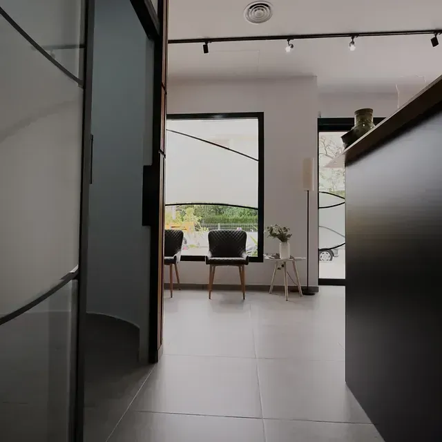 Una sala de espera con sillas y una gran ventana.