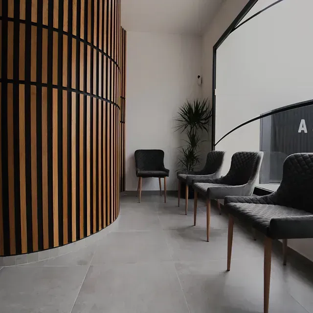 Una fila de sillas en una sala de espera con una pared de madera.