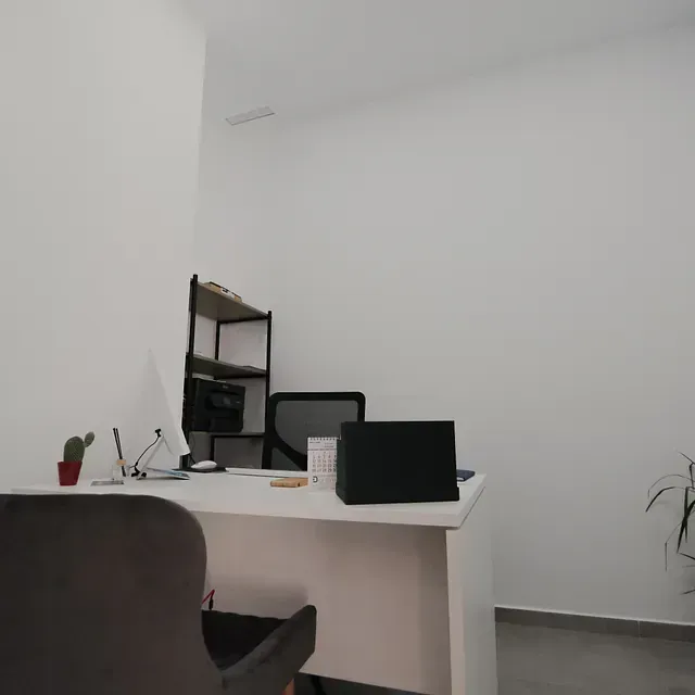 Un escritorio con una computadora portátil encima en una habitación.