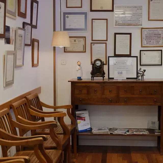 Una habitación con un reloj encima de una mesa de madera.
