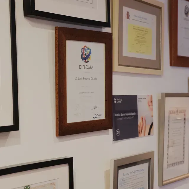 Varios diplomas enmarcados están colgados en una pared.