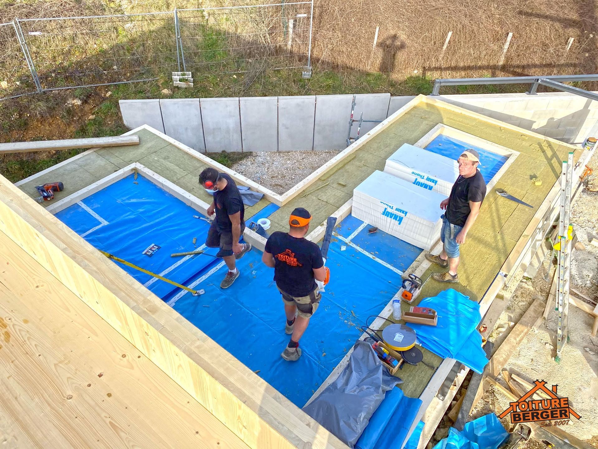 Des ouvriers préparent un chantier d'isolation de toiture
