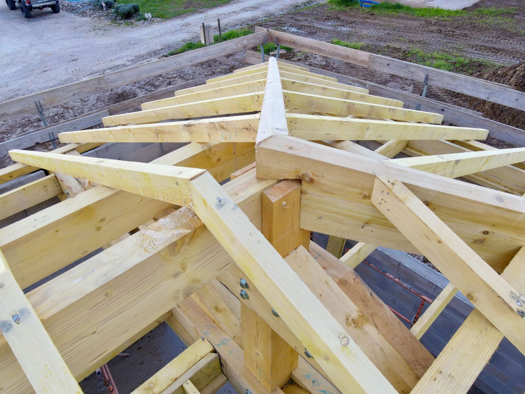Des fermes de toit en bois en cours de construction sur la charpente d’une maison, vues de dessus.