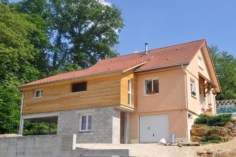 Maison à un étage avec un toit en tuiles rouges, une façade en bois et en stuc
