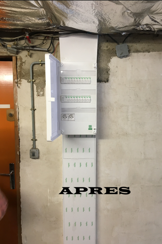 Une boîte blanche est accrochée sur un mur à côté d'une porte.