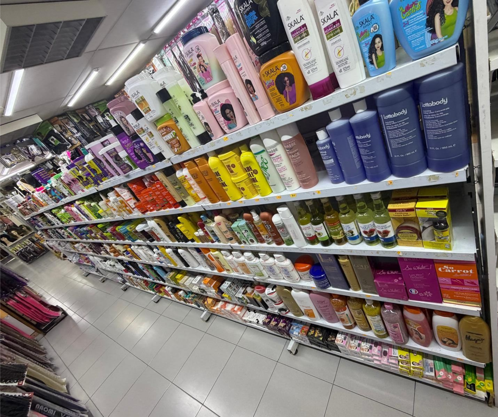 Pasillo de estanterías de supermercado repleto de coloridos productos para el hogar y el cuidado personal.