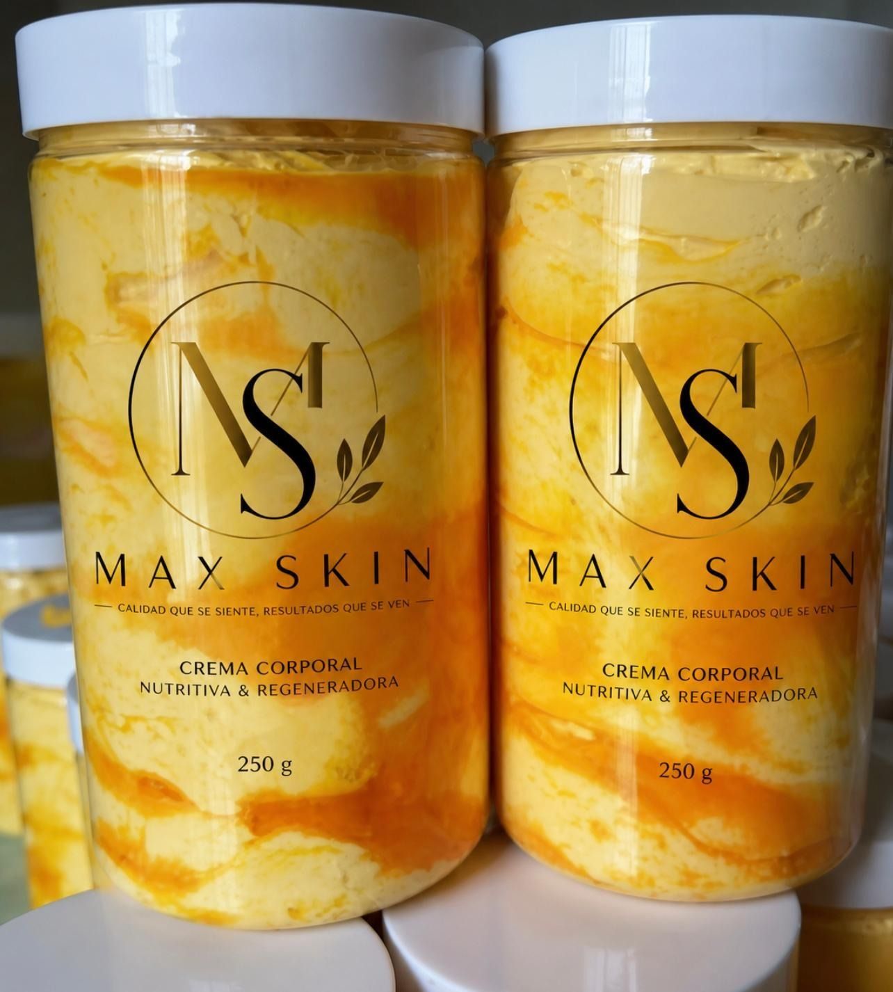 Dos tarros de crema Max Skin de color amarillo anaranjado con tapas blancas en un estante.