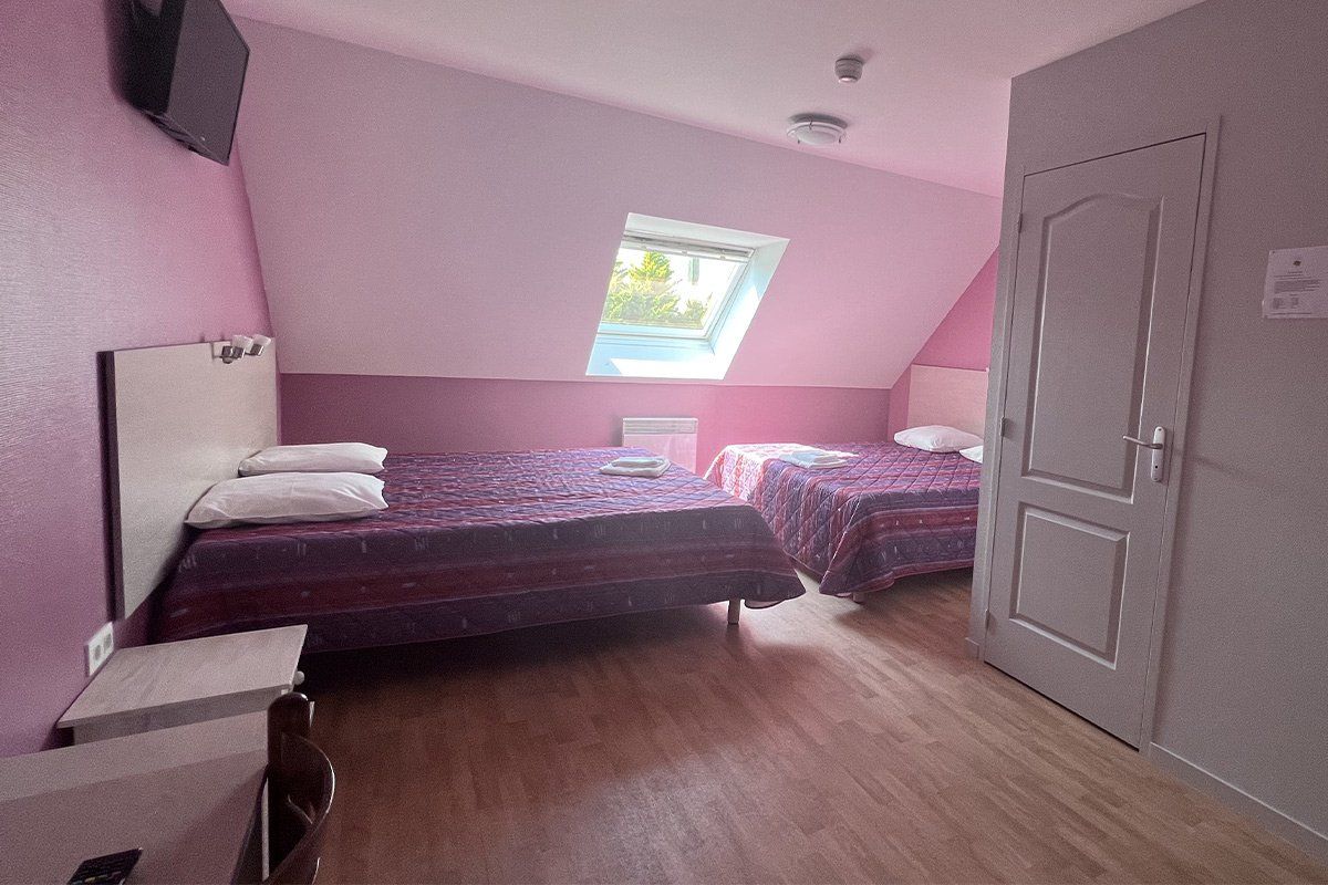 Chambre aux tons rose avec deux lits doubles