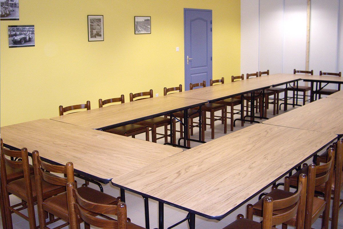 Salle de réunion pour entreprises où les tables forment un rectangle