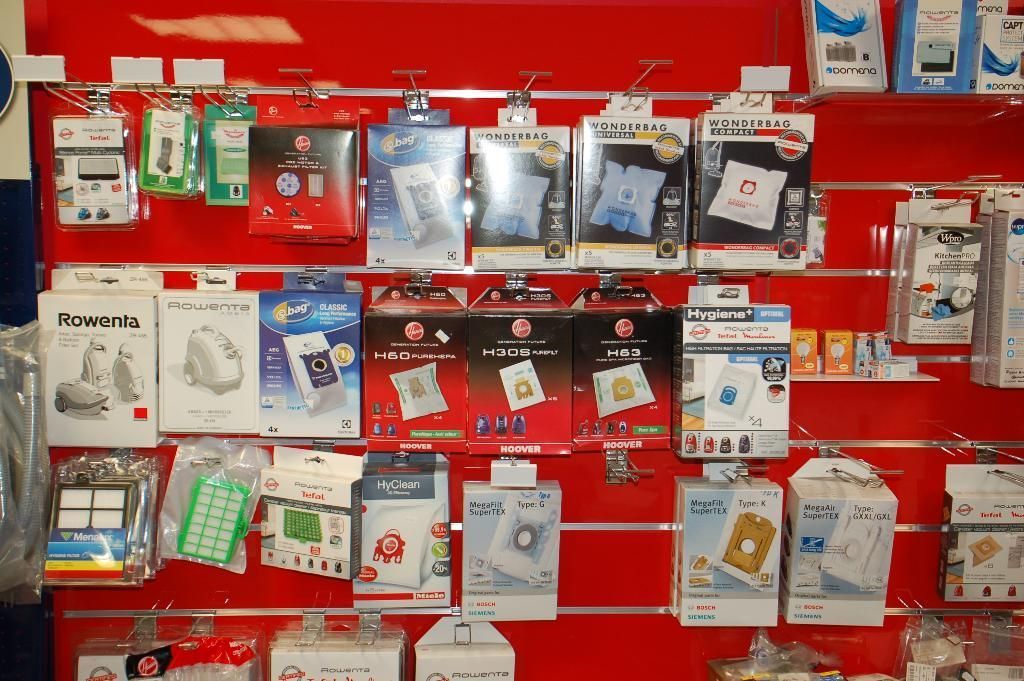 Présentoir rouge rempli d'accessoires pour téléphones portables, présentés dans des emballages.
