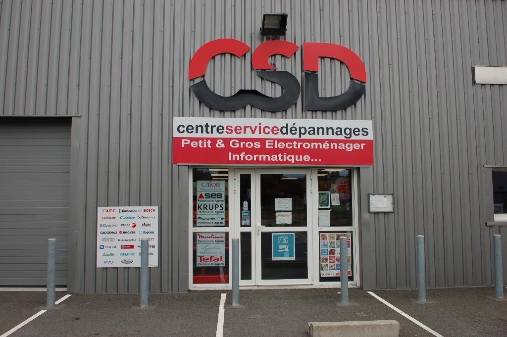 Façade de CENTRE SERVICES DÉPANNAGES avec enseigne rouge et blanche et portes d'entrée vitrées.