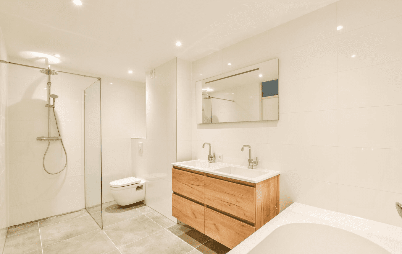 Salle de bain moderne avec vanité en bois, murs blancs, douche en verre et baignoire.