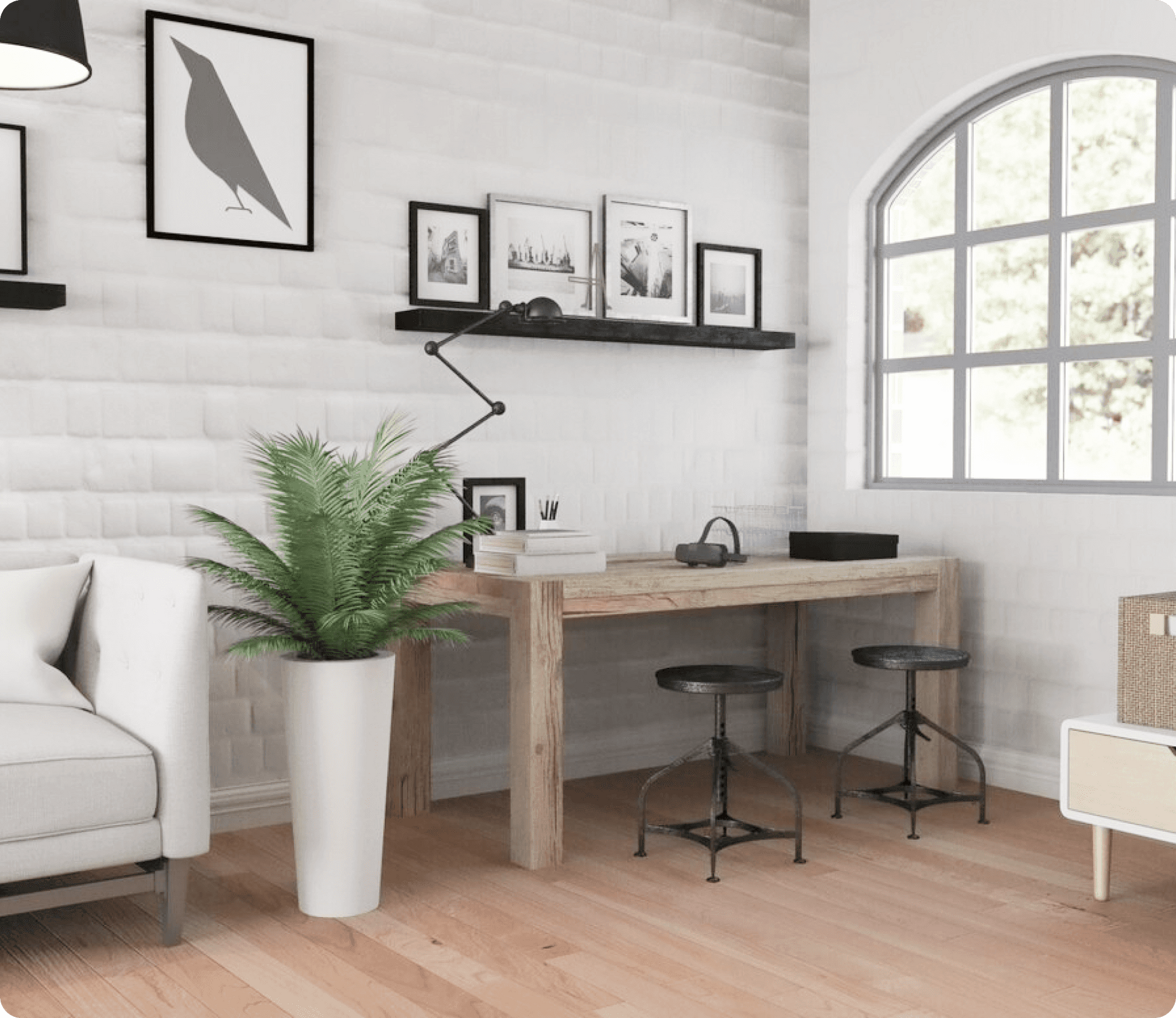 Chambre avec bureau, tabourets, art, plantes, fenêtre cintrée et canapé contre un mur de briques blanches.