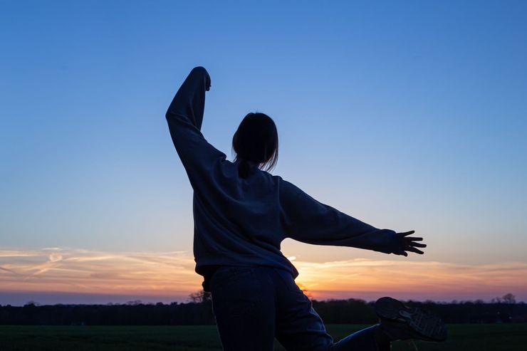 Salle de massage à l'éclairage tamisé, avec des lumières rose-violettes, des bougies et une décoration murale à motifs.