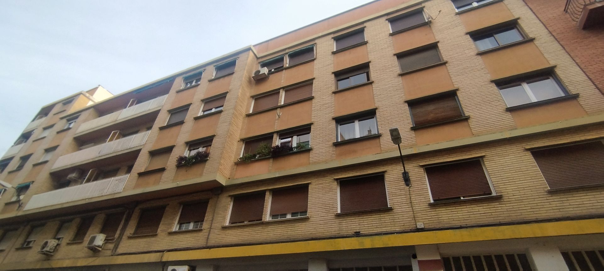 Una puerta de garaje roja está cerrada delante de un edificio.