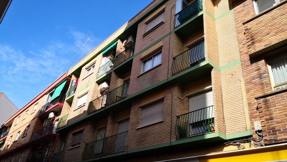 Un edificio grande con muchas ventanas y árboles delante de él.