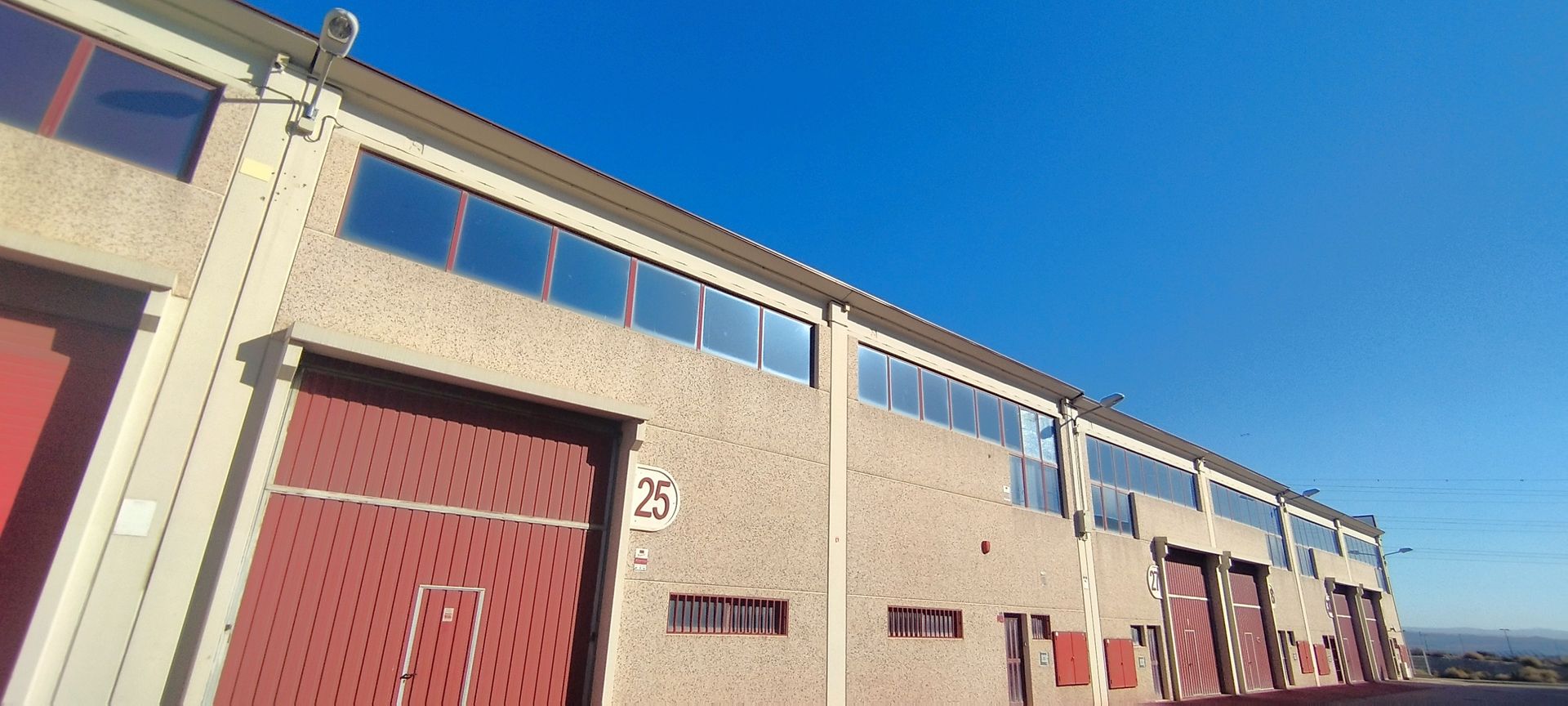 Un edificio grande con muchas ventanas y árboles delante de él.