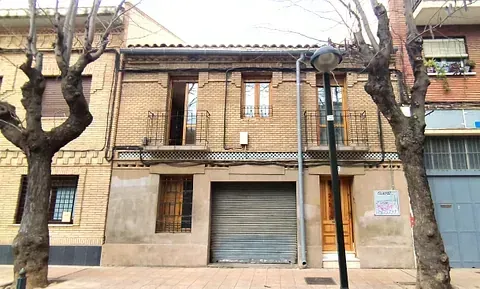Un edificio de ladrillo con garaje y balcón.