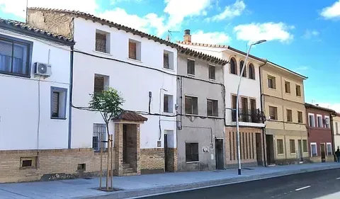 Una fila de edificios están alineados al costado de una calle.
