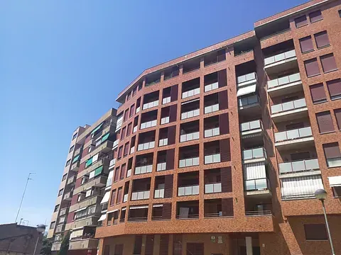 Un gran edificio de ladrillo con muchas ventanas y balcones.