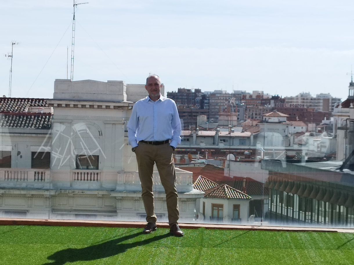 Un hombre parado en un tejado con vistas a una ciudad.