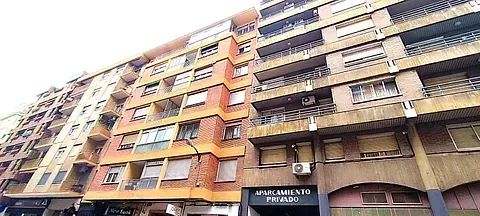 Un gran edificio de apartamentos con muchas ventanas y balcones.