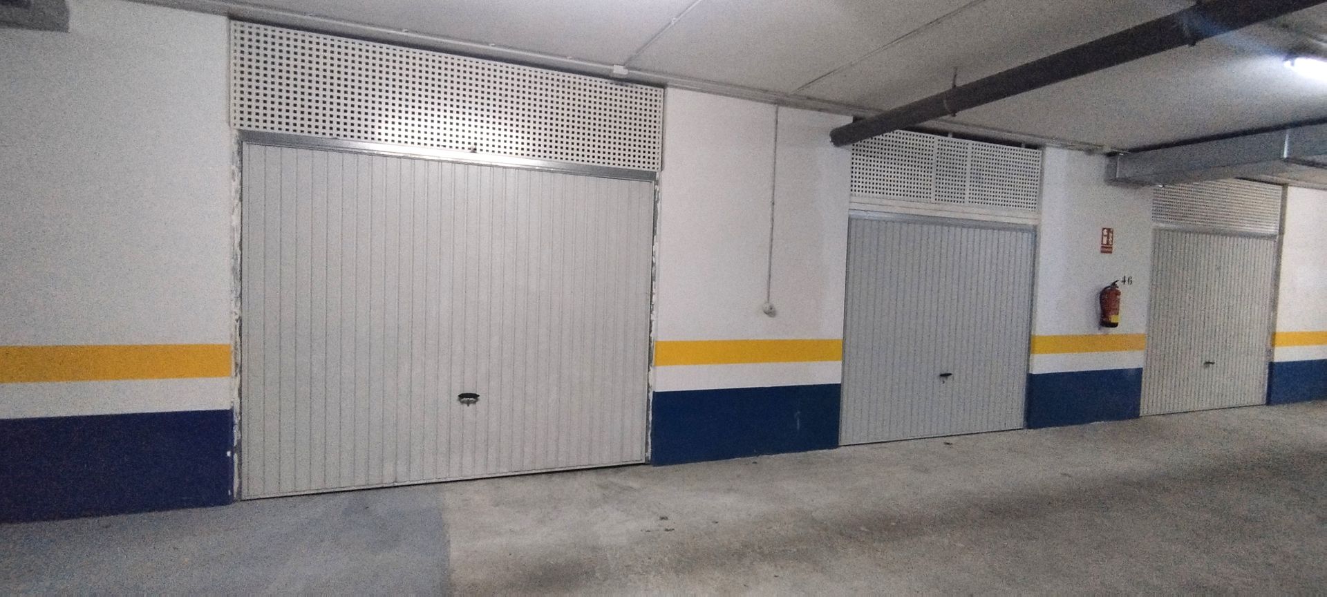 Un edificio con un coche aparcado delante.