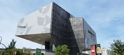 Un edificio grande con muchas ventanas y árboles delante de él.