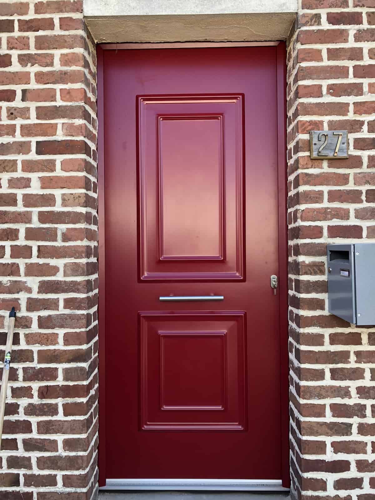 Porte en bois rouge et mur de briques