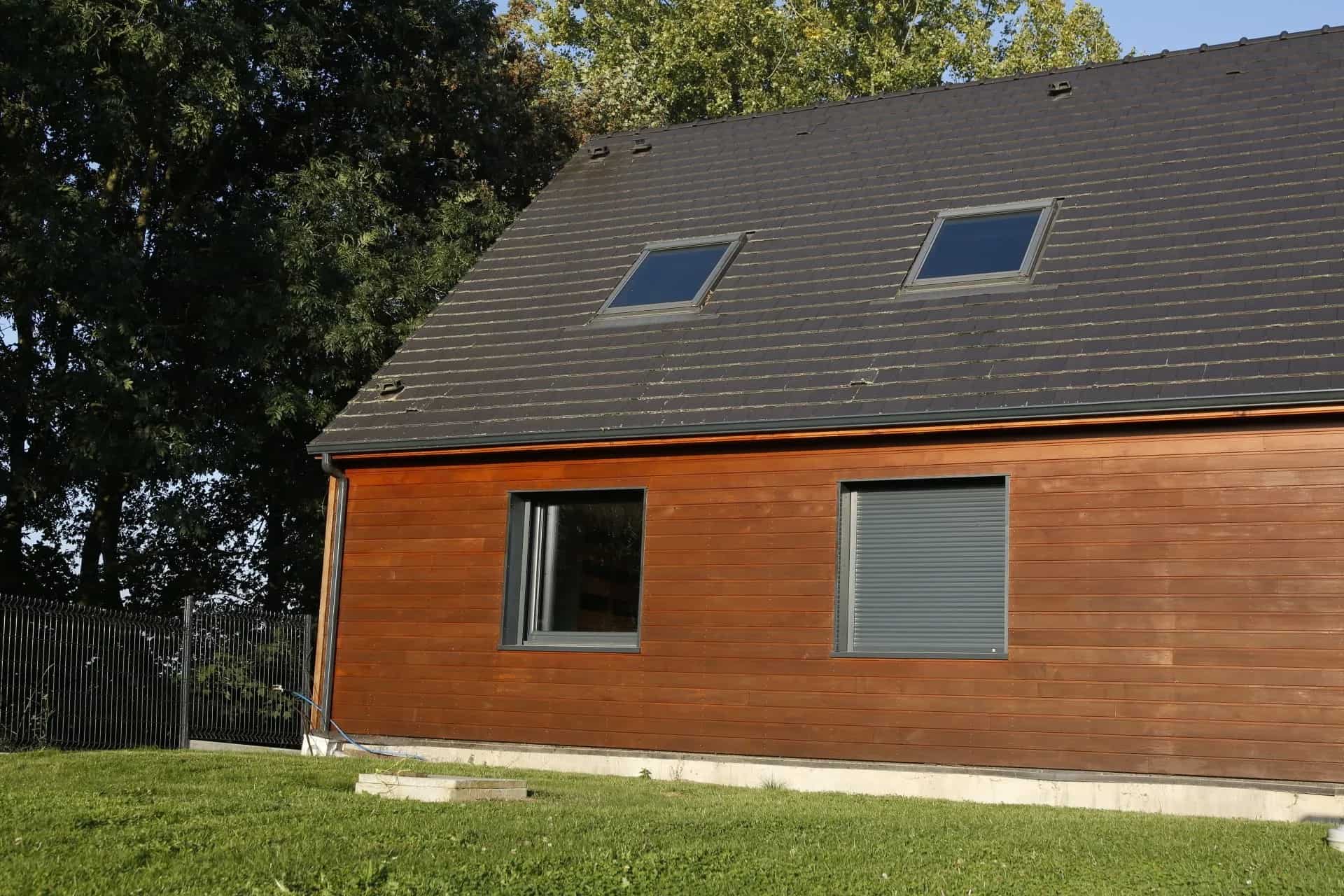 Volets roulants noirs sur maison en bois