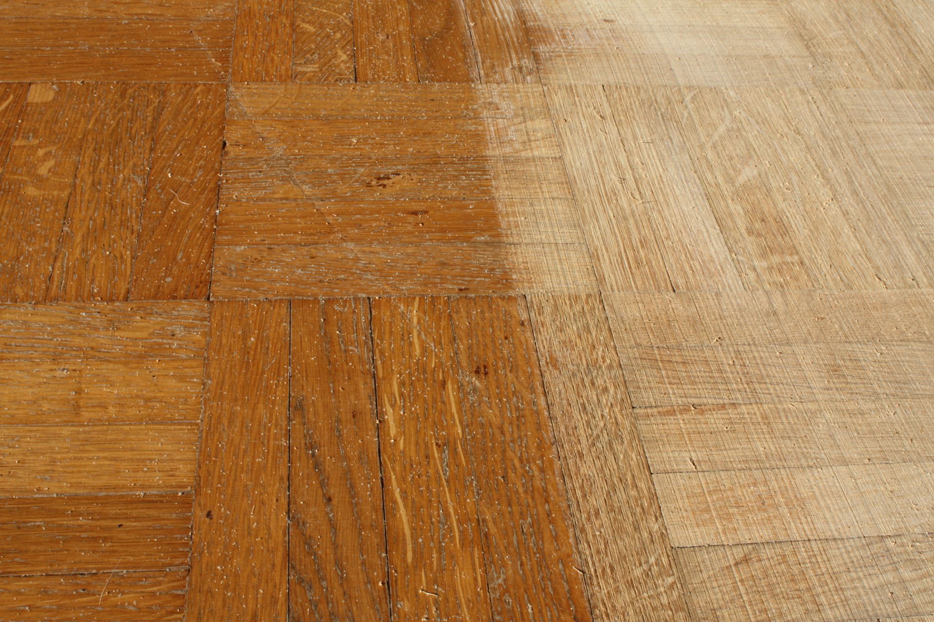 Gros plan sur un parquet en bois usé, composé de lames marron clair et foncé.