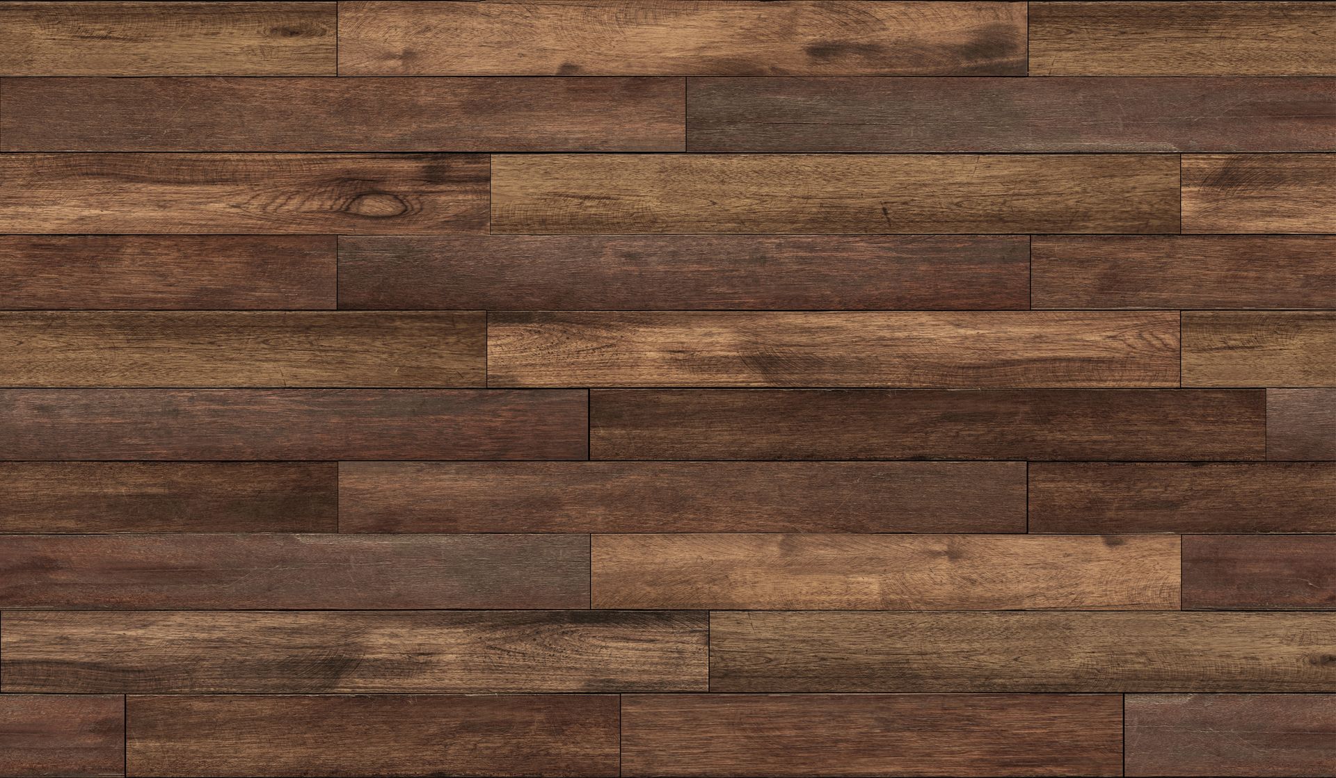 Un parquet en bois composé de lames horizontales brunes et beiges patinées.
