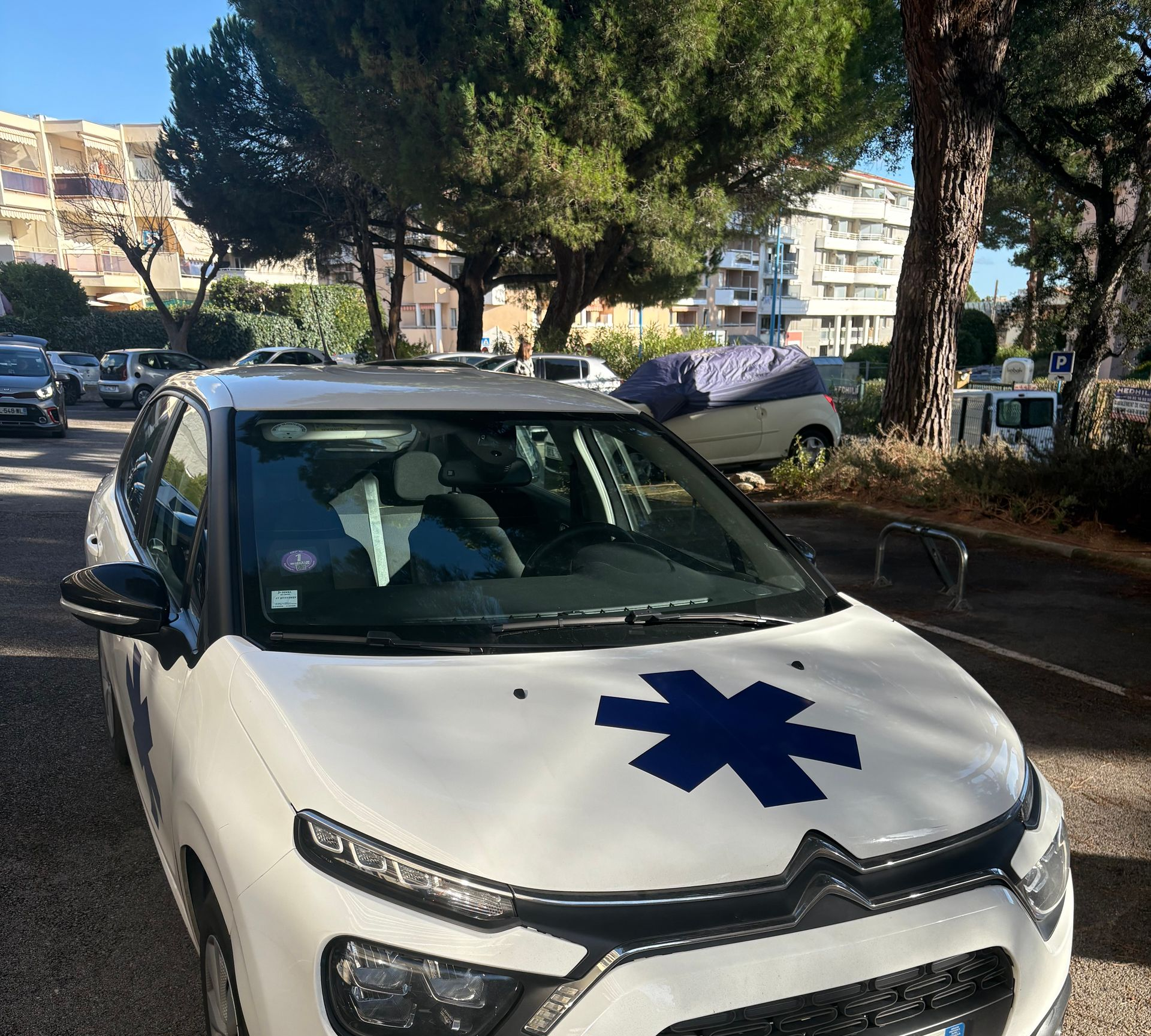 Ambulance avec un emblème en forme d'étoile, stationnée à l'extérieur.