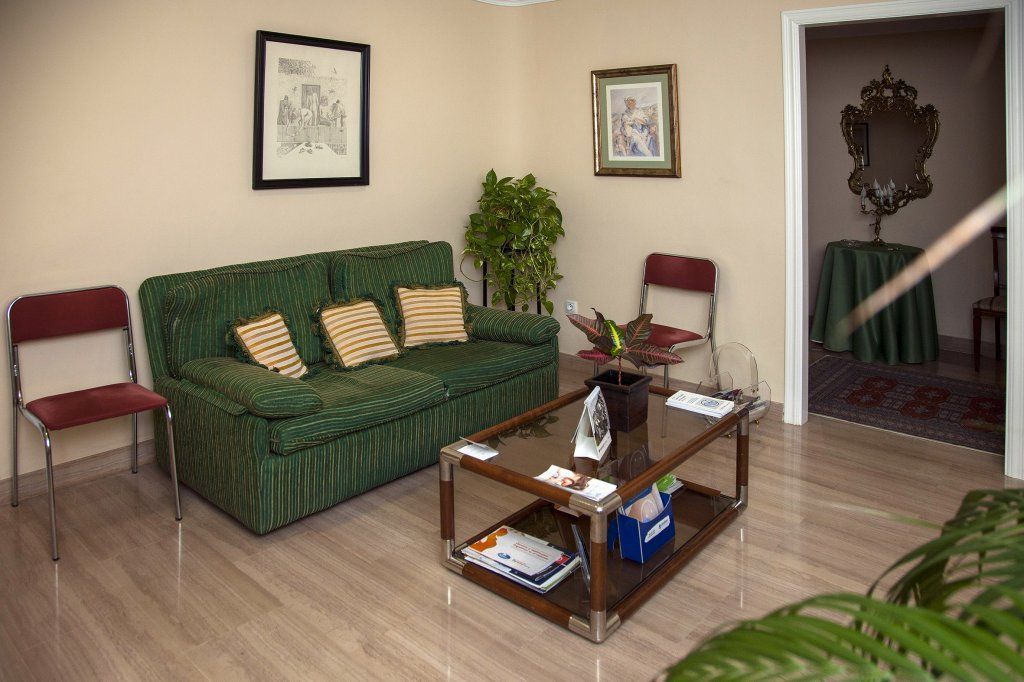 Una sala de estar con un sofá verde y una mesa de café.