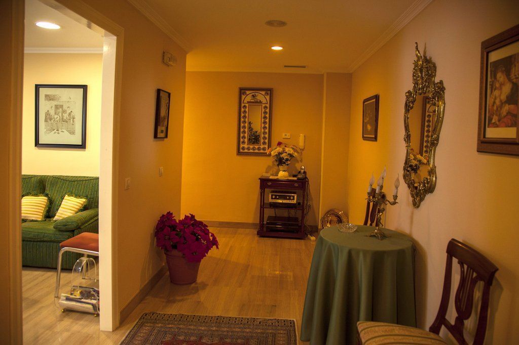 Una sala de estar con una mesa y sillas verdes.