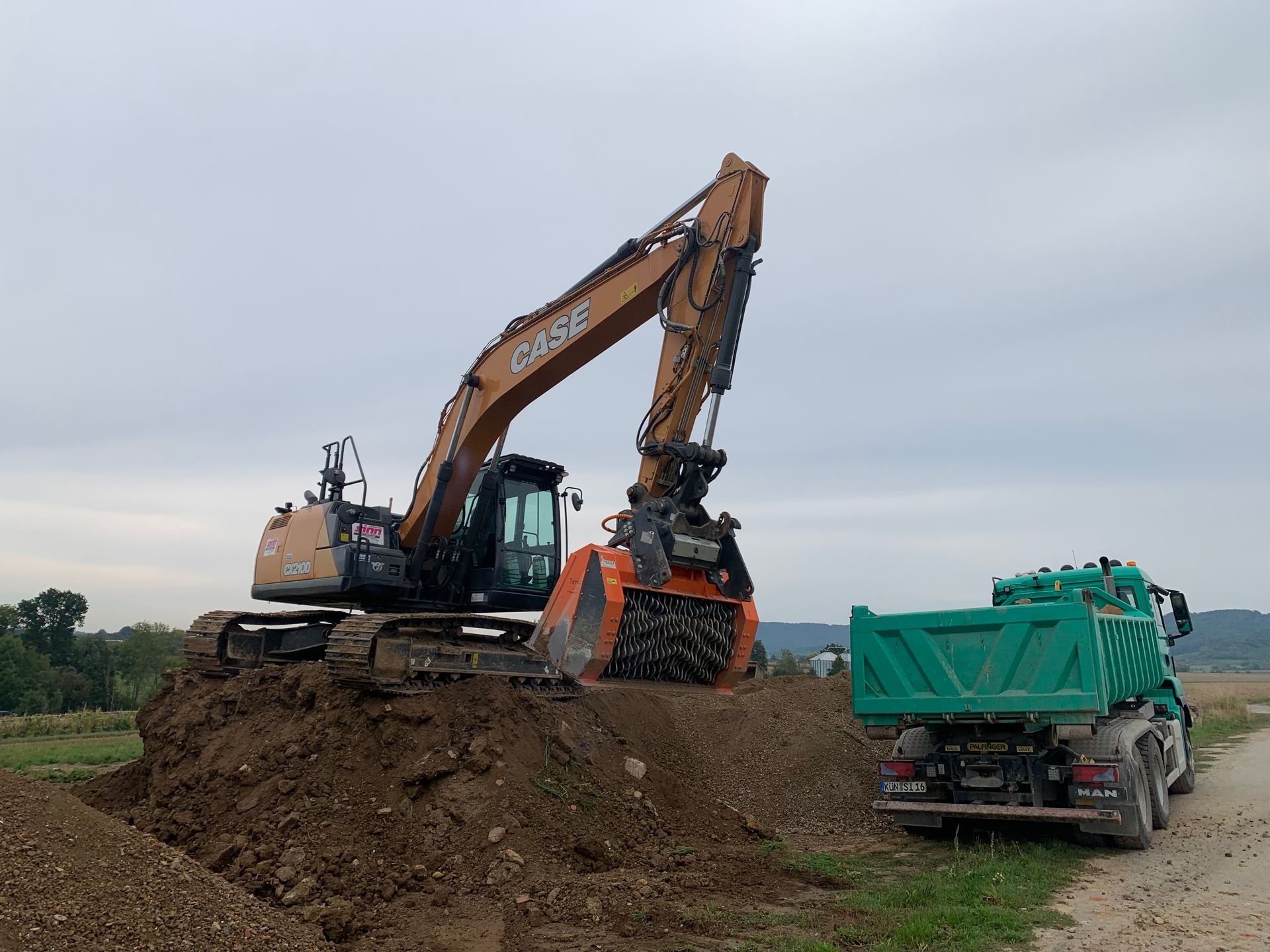 Gelber Bagger auf Erdhügel