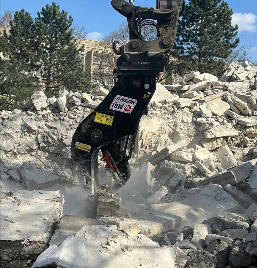 Ein großer Steinhaufen wird von einer Maschine abgetragen.
