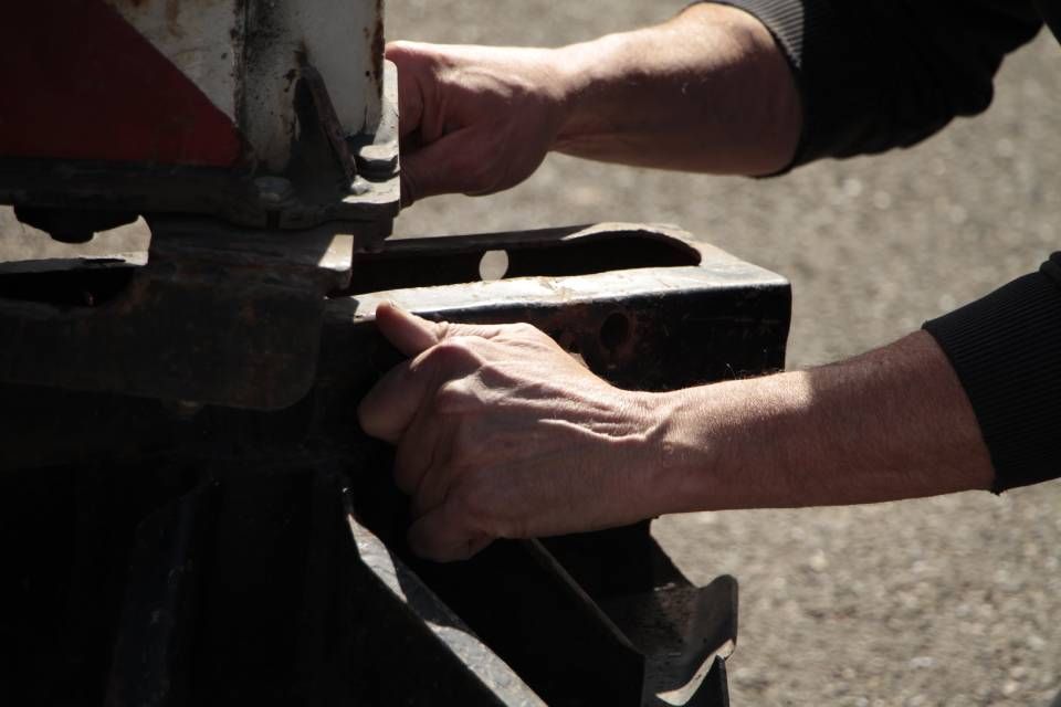 Eine Nahaufnahme der Hände einer Person, die an einem Stück Metall arbeitet