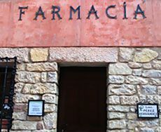Fachada de piedra de una farmacia con la palabra 