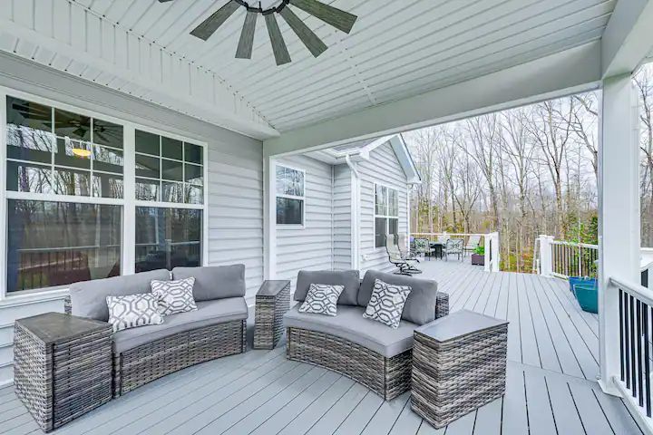 There is a ceiling fan on the porch of a house.