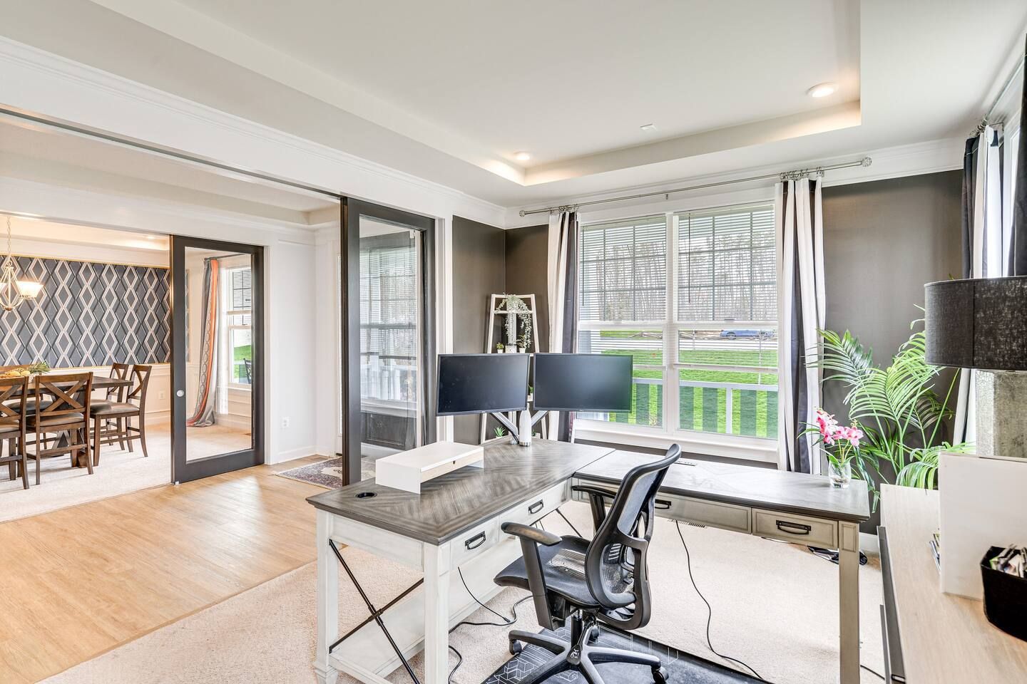 A home office with a desk and two computer monitors.