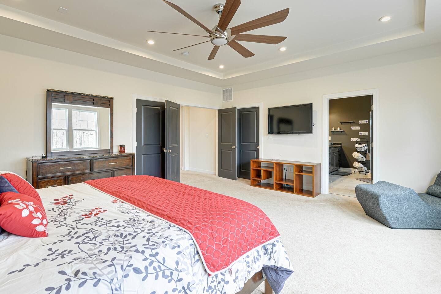 A bedroom with a large bed and a ceiling fan.