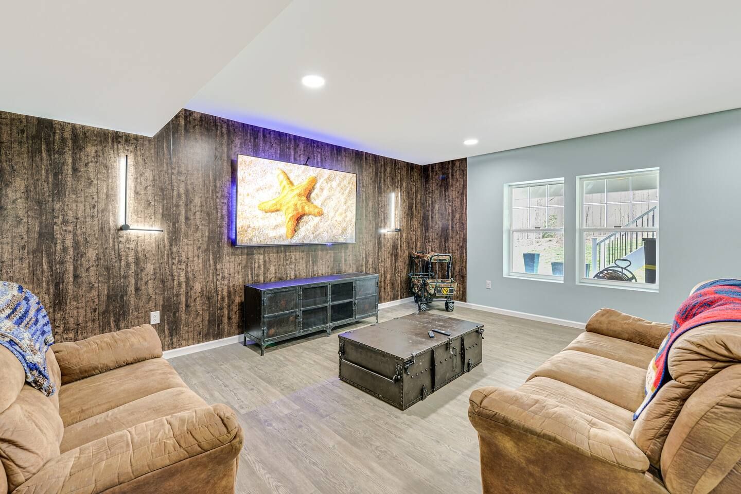 A living room with two couches , a coffee table , and a flat screen tv.