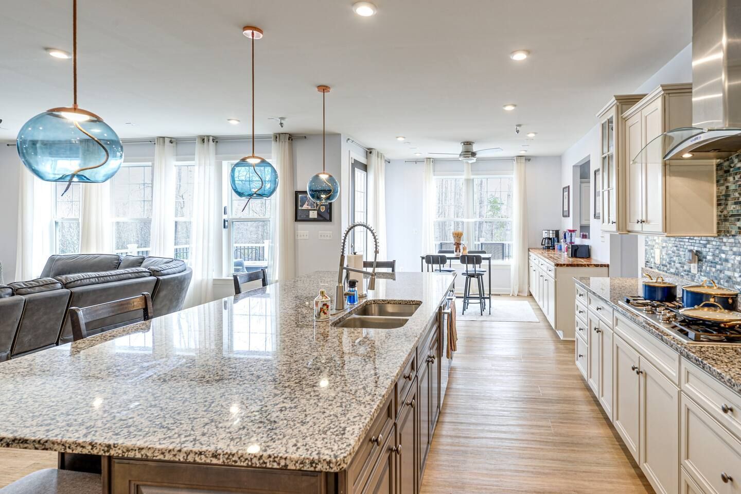 A kitchen with granite counter tops , stainless steel appliances , and white cabinets.