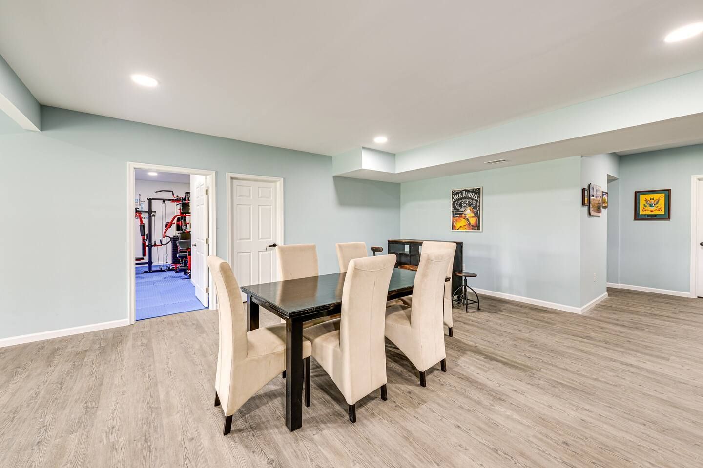 A dining room in a basement with a table and chairs.