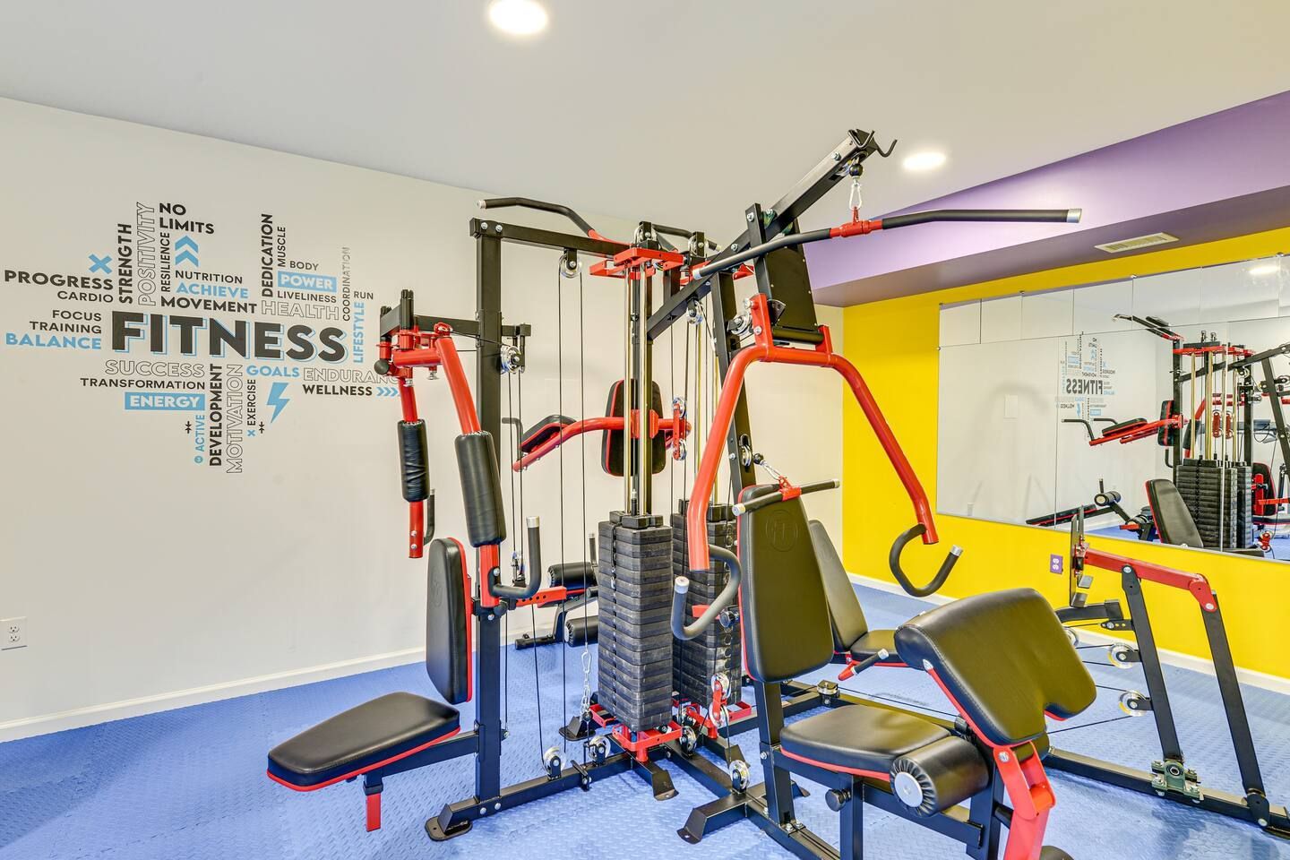 A gym with a lot of exercise equipment and a large mirror.